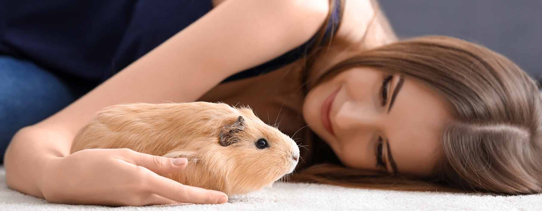 girls lying down with cute beige guinea pig
